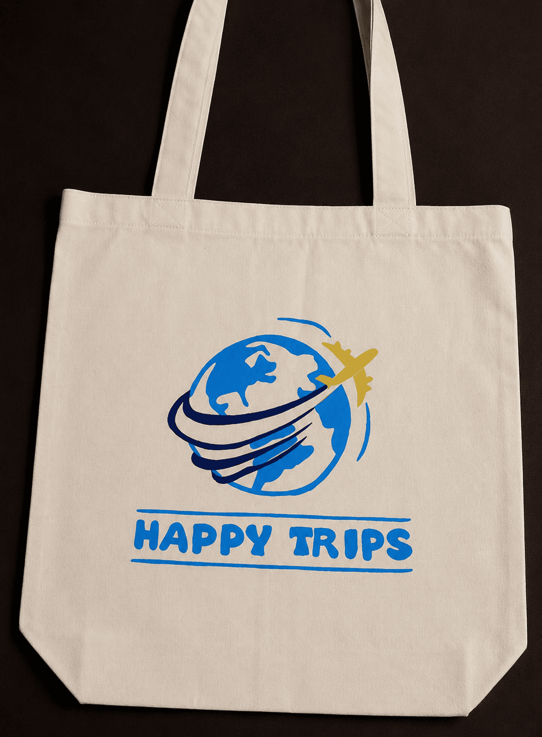 Natural tote bag printed with a 'Happy Trips' brand design